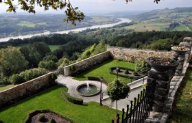 Garten mit Brunnen und Blick auf Flusslandschaft, umgeben von Steinmauern., © Pfarre Maria Taferl