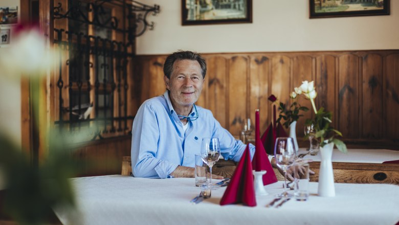 Mann in einem gemütlichen Restaurant mit Holzwänden und Tischdekoration., © Niederösterreich Werbung/David Schreiber