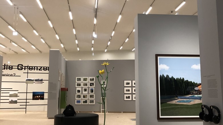 Moderne Kunstausstellung mit Skulptur und Fotografien an grauen Wänden., © Donau NÖ Tourismus/JS